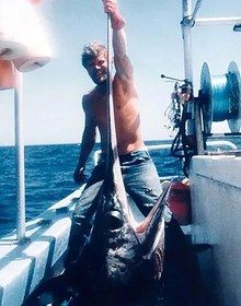 Captain Michael Black holding a swordfish